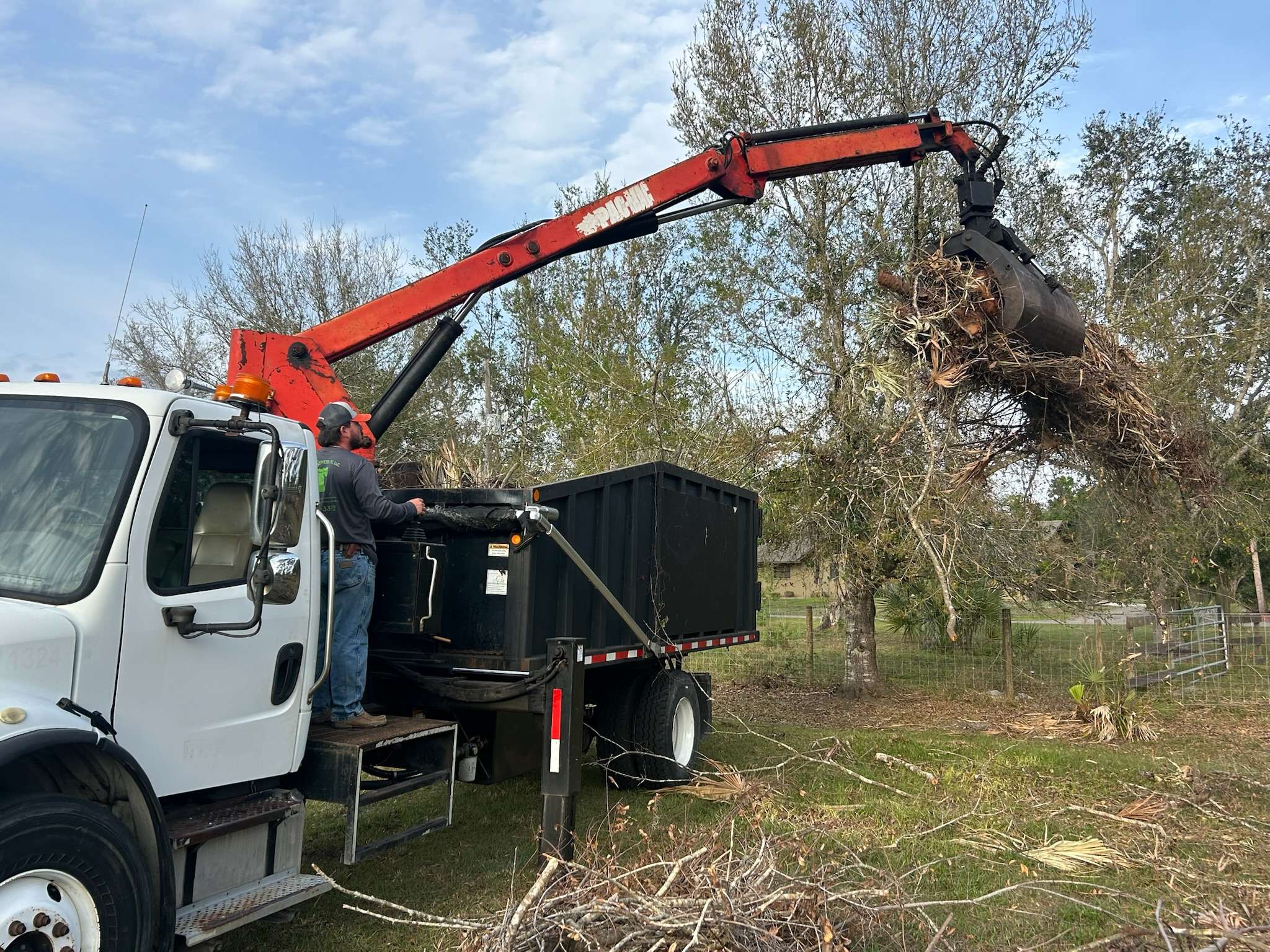 Picking up tree and land debris with our grapple truck.
