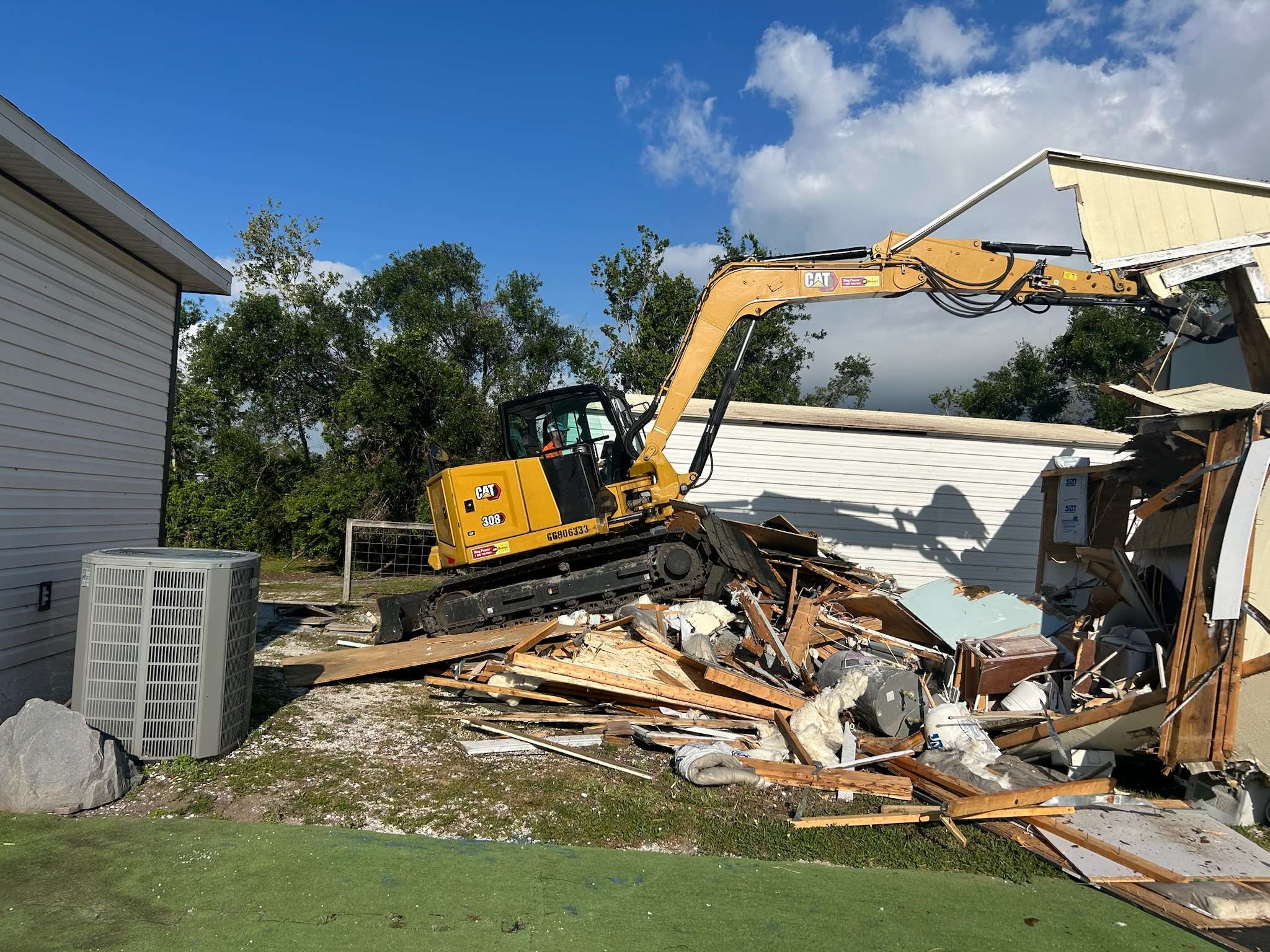 Yellow excavator used to demo an old barn.