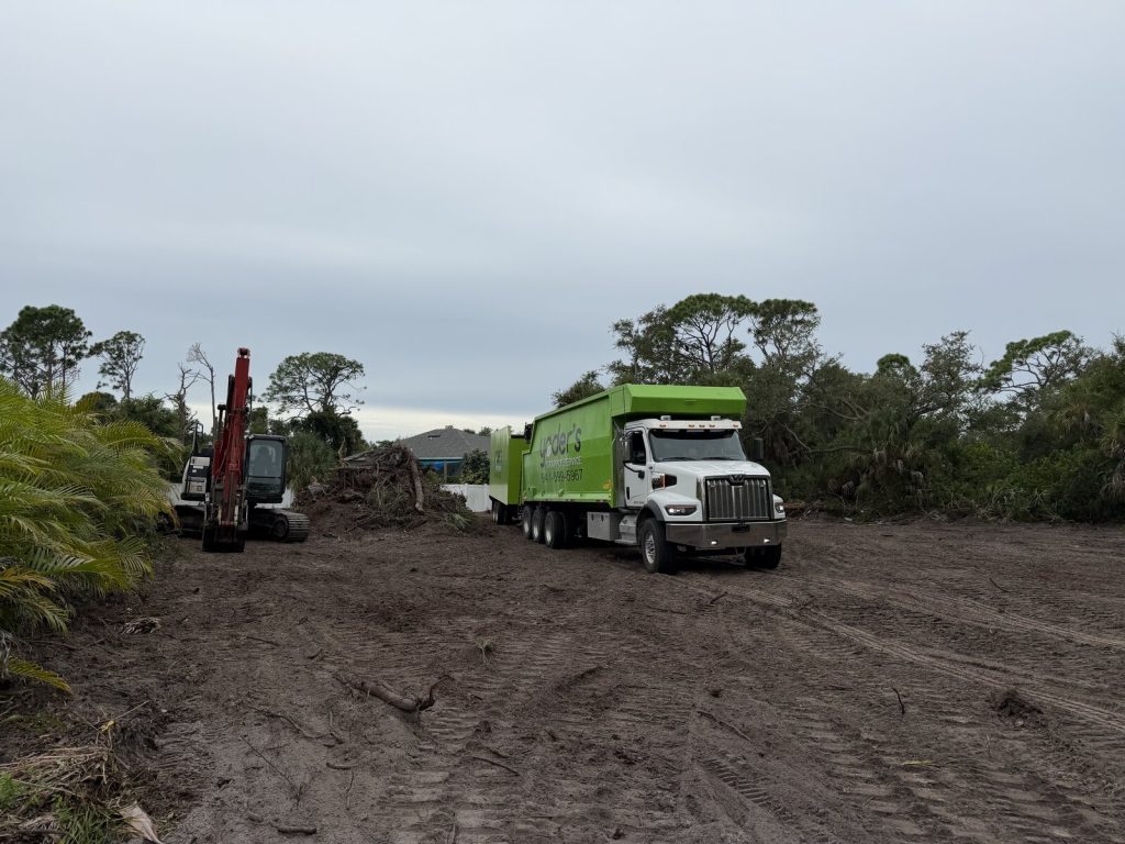 Dump truck and excavator working on a cleared residential site