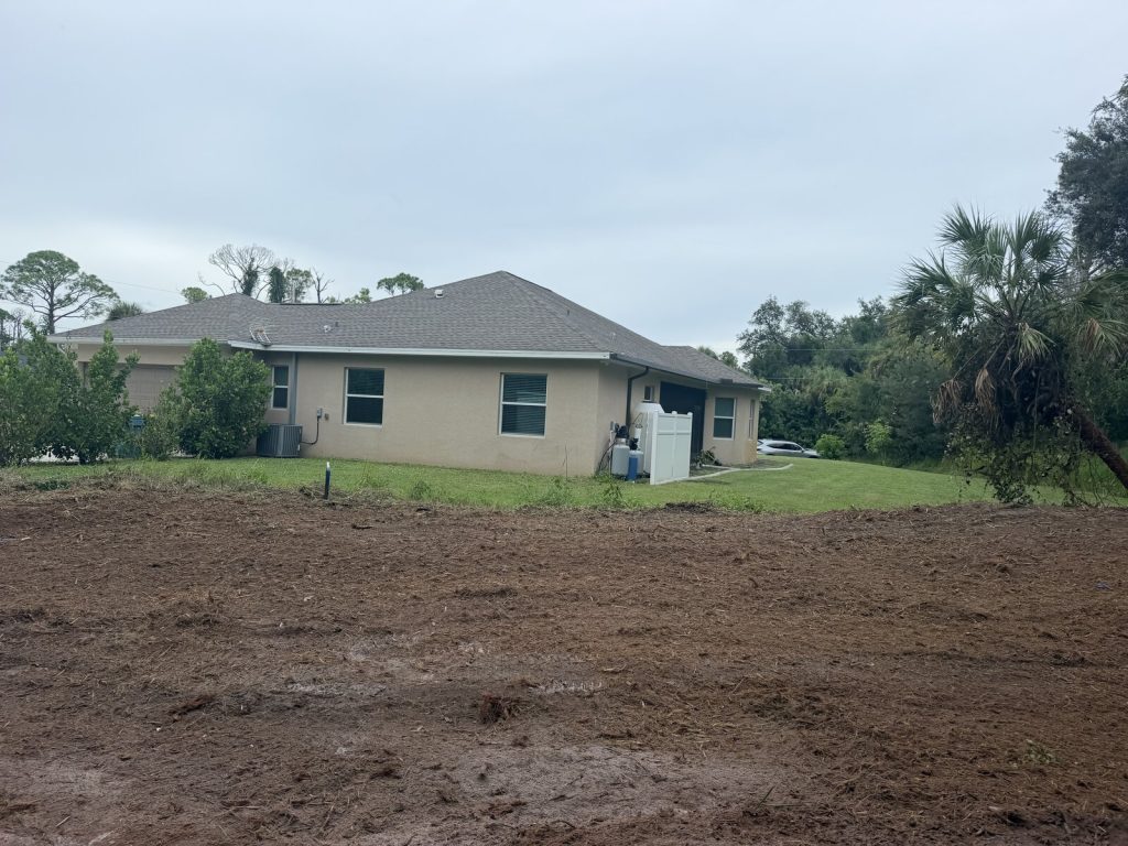 Open mulched and cleared ground beside a residential home