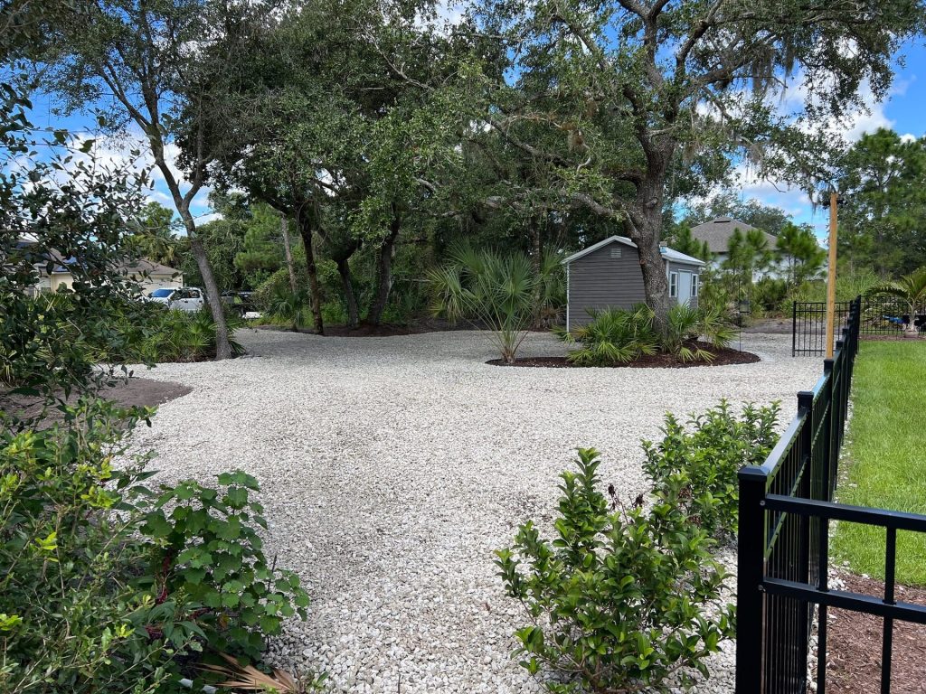 Decorative rock driveway and planted landscape beds installed by Liberty Services