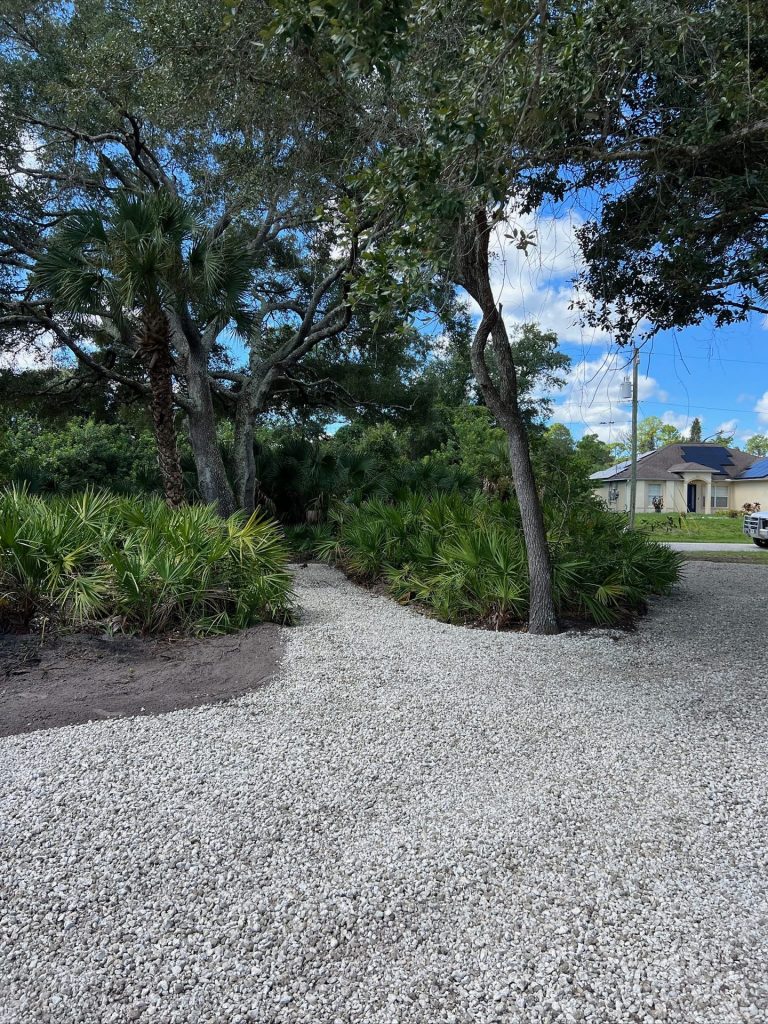 Crushed rock driveway winding through native landscape plantings