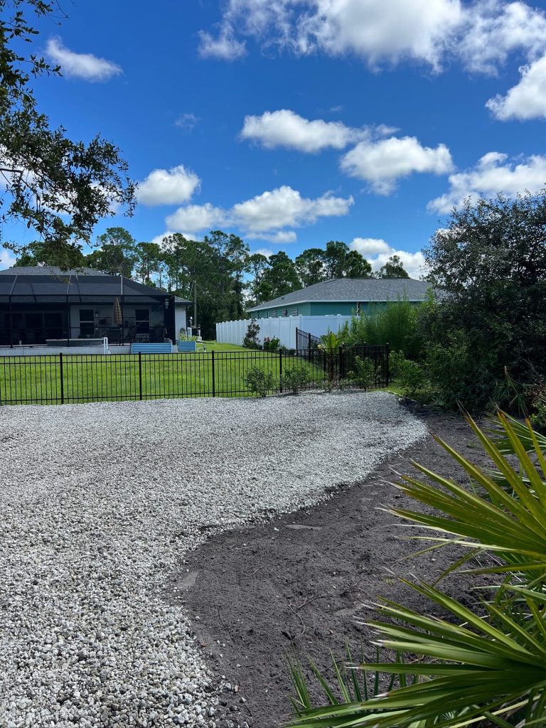 Curved decorative rock driveway edge with fresh landscape beds