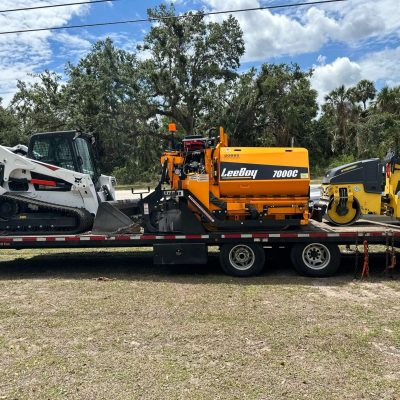 Asphalt paving equipment on a trailer getting ready for a job site.