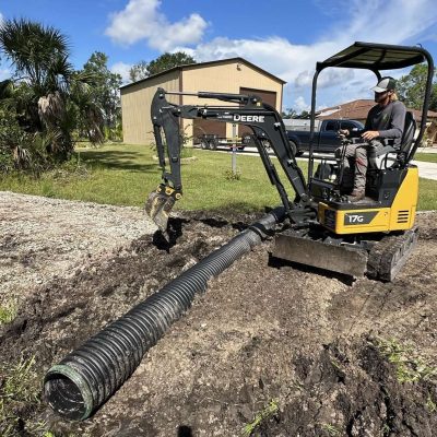 Yellow excavator digging out a culvert to be installed.