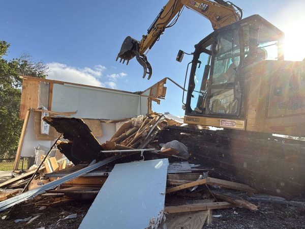 IMG_0502 2 Yellow excavator doing a demolition of a house.