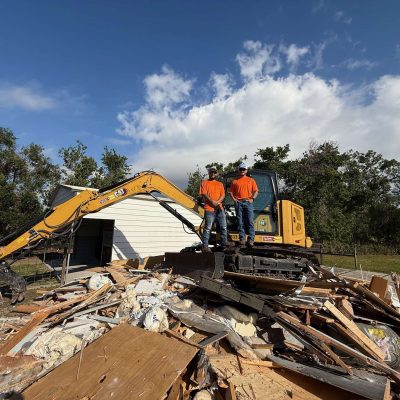 Demolition done by Liberty Tree and Land Services with a yellow excavator.