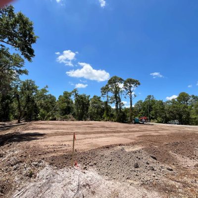 Site graded with excavation equipment to prepare for a construction project.