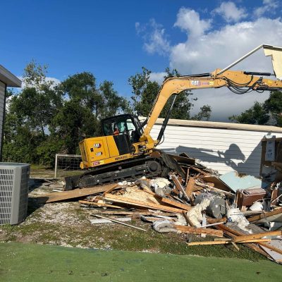 Yellow excavator used to demo an old barn.