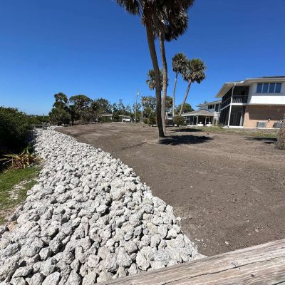 Yard graded with excavation equipment to prepare for sod installation.
